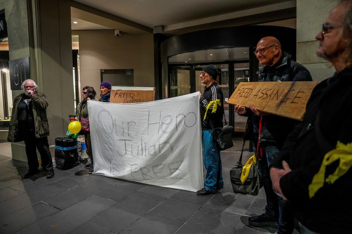 Un grupo de personas recibe a Assange con un cartel que reza "nuestro héroe". Foto: Reuters