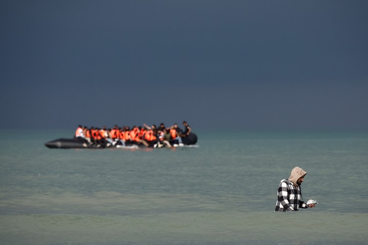 Un migrante busca abordar un bote inflable para cruzar hacia Inglaterra. Foto: Reuters 