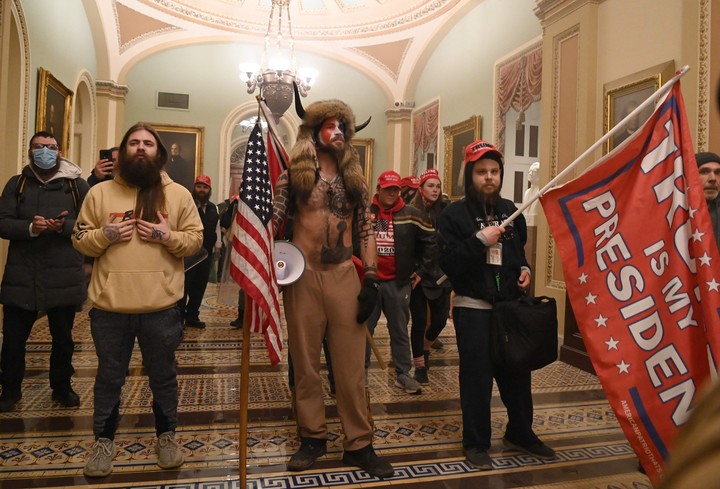 Partidarios del presidente estadounidense Donald Trump, incluido el miembro del grupo conspirativo QAnon Jake Angeli, también conocido como Yellowstone Wolf (centro), ingresan al Capitolio de Estados Unidos el 6 de enero de 2021 en Washington. Foto AFP