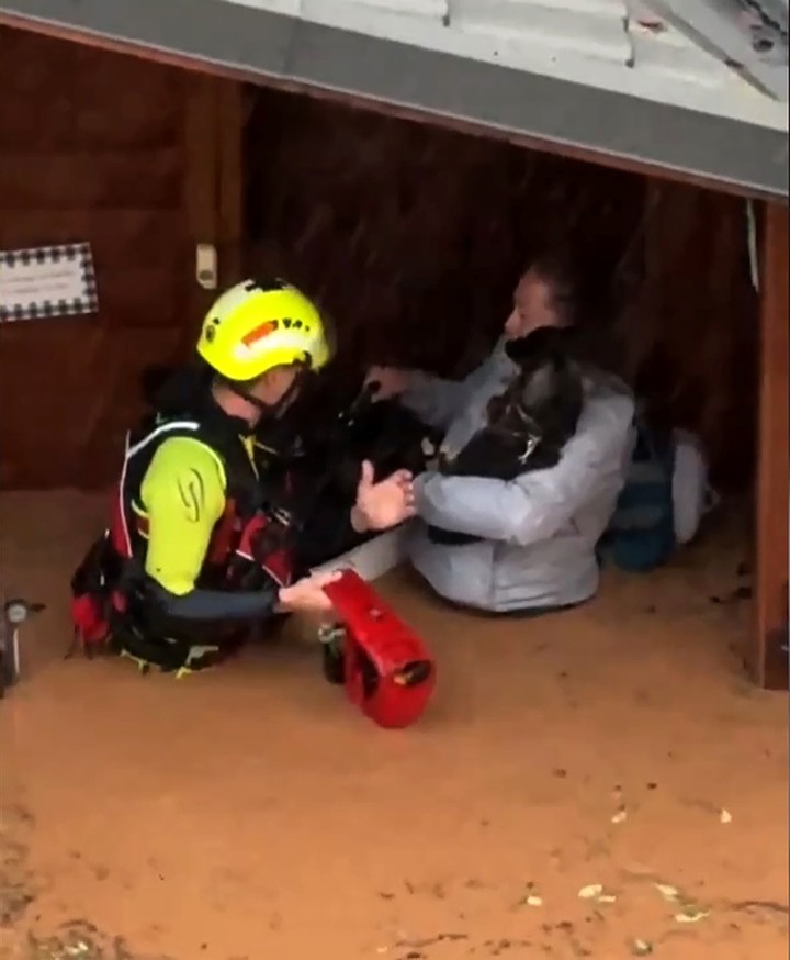 Fuerzas de socorro rescatando a una mujer dentro de una inundación en Valencia. Foto: EFE