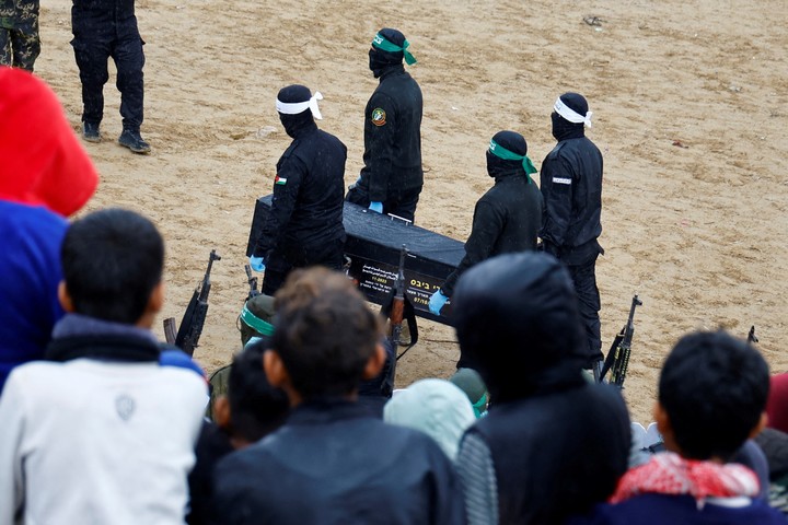 Militantes palestinos llevan un ataúd el día en que Hamas entrega a los rehenes fallecidos Oded Lifschitz, Shiri Bibas y sus dos hijos Kfir y Ariel Bibas, secuestrados durante el mortal ataque. Foto REUTERS/Hatem Khaled