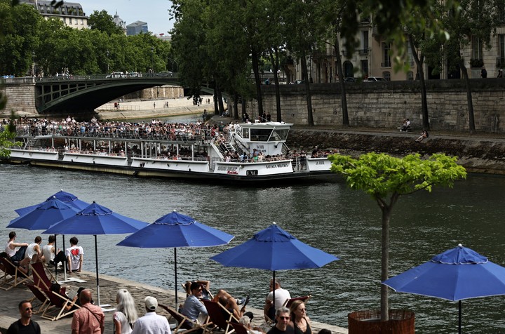 Personas disfrutando de su tiempo libre de verano frente al río Sena, en París, Francia. Foto Xinhua