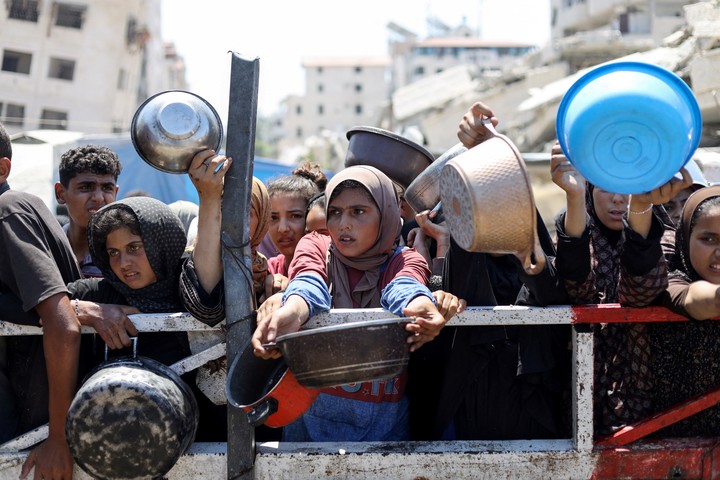Palestinos esperan recibir comida de un comedor social, en medio de una crisis de hambre, en la ciudad de Gaza. Foto Reuters