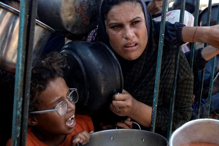 Palestinos piden comida en una cocian comunitaria. Foto: EFE