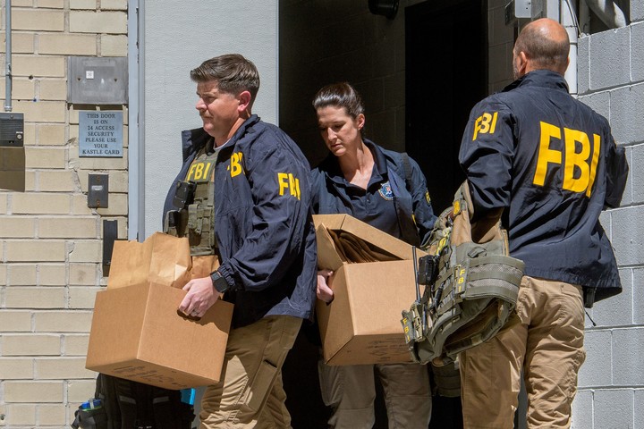 Agentes del FBI se llevan cajas de la casa de John Bolton, tras el allanamiento de este viernes. Foto: AP  
