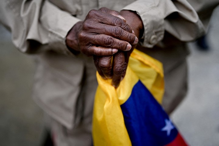 Un miembro de la Milicia Bolivariana de Venezuela con una bandera venezolana espera el día en que el presidente de Venezuela. Foto EFE