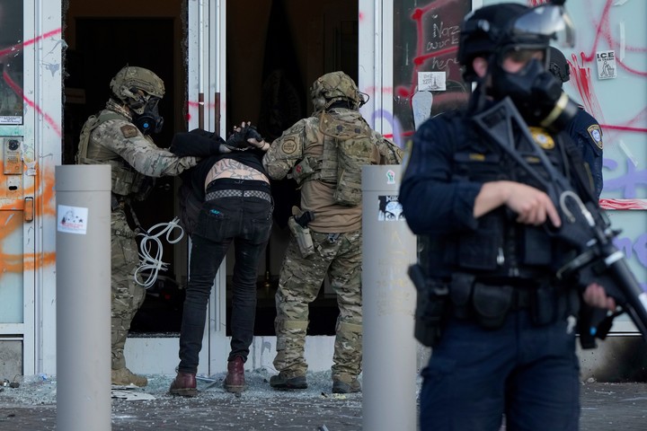 Agentes de Aduanas y Protección Fronteriza de EE. UU. detienen a un hombre frente al edificio de Inmigración y Aduanas de EE. UU. durante una protesta en Portland, Oregón. Foto AP