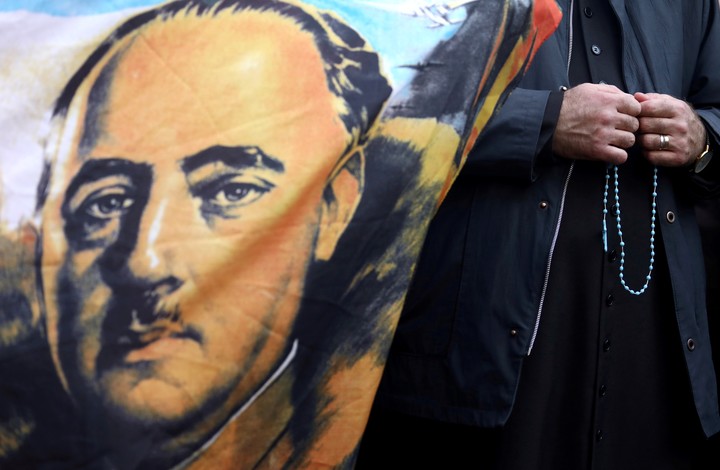 Un sacerdote reza junto a un retrato del dictador español Francisco Franco, en Madrid. Foto: REUTERS 