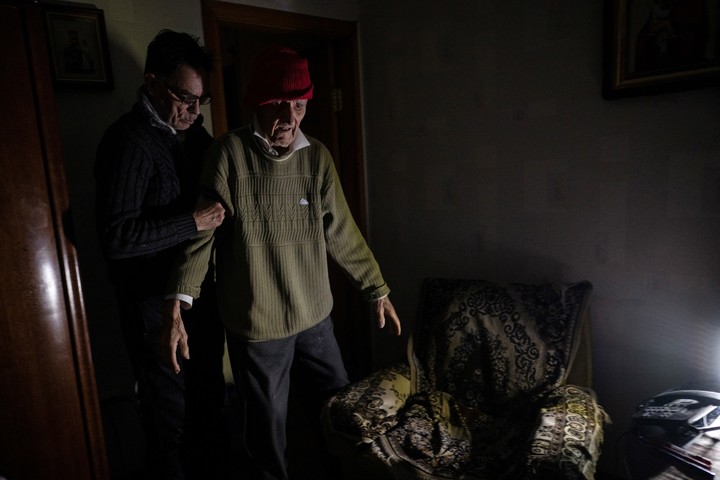 Volodymyr Matveyev calienta a su padre de 99 años colocando bolsas de agua caliente en su cama en Kiev, Ucrania, el 31 de enero de 2026.  (Lynsey Addario/The New York Times)