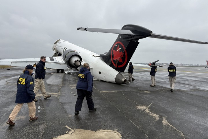 Investigadores de la Junta Nacional de Seguridad del Transporte (NTSB) inspeccionan los restos del avión de Air Canada. Foto Reuters 