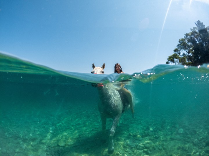Lara Grbac, de 14 años, monta a caballo, llamado «Perlaz», en el agua durante una ola de calor en Supetar, en la isla de Brac, Croacia, el 5 de agosto de 2026. REUTERS/Antonio Bronic