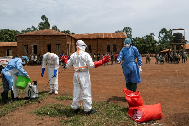Los trabajadores sanitarios se desinfectan tras recuperar el cadáver del señor Okito. Cuando llegaron los primeros trabajadores, llevaba muerto menos de 30 minutos. Fotos de Arlette Bashizi para The New York Times.
