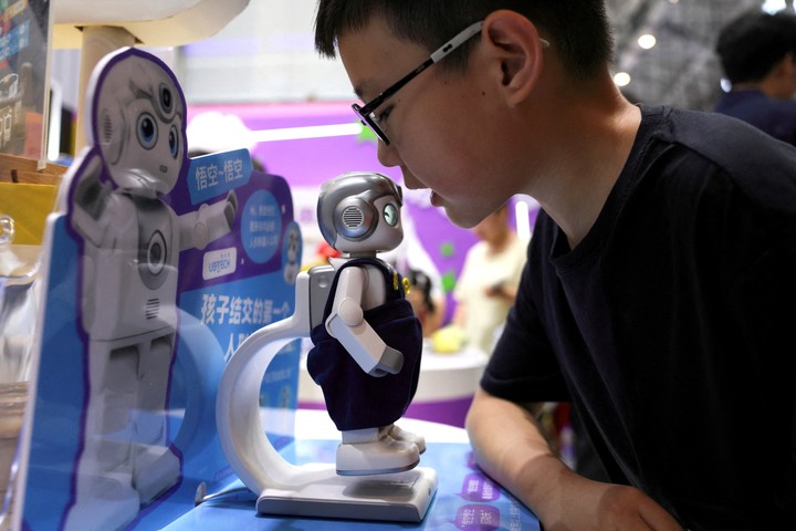 Un niño habla con un robot Wukong de UBTech AI, que está a la venta, durante la Conferencia Mundial de Robótica de 2026, celebrada en Pekín, China, el 21 de agosto de 2026. REUTERS/Tingshu Wang     