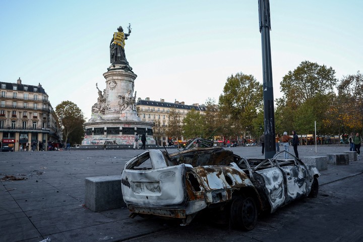 Un automóvil destruido cerca de la estatua de Marianne en la plaza de la República, en París. Foto Reuters